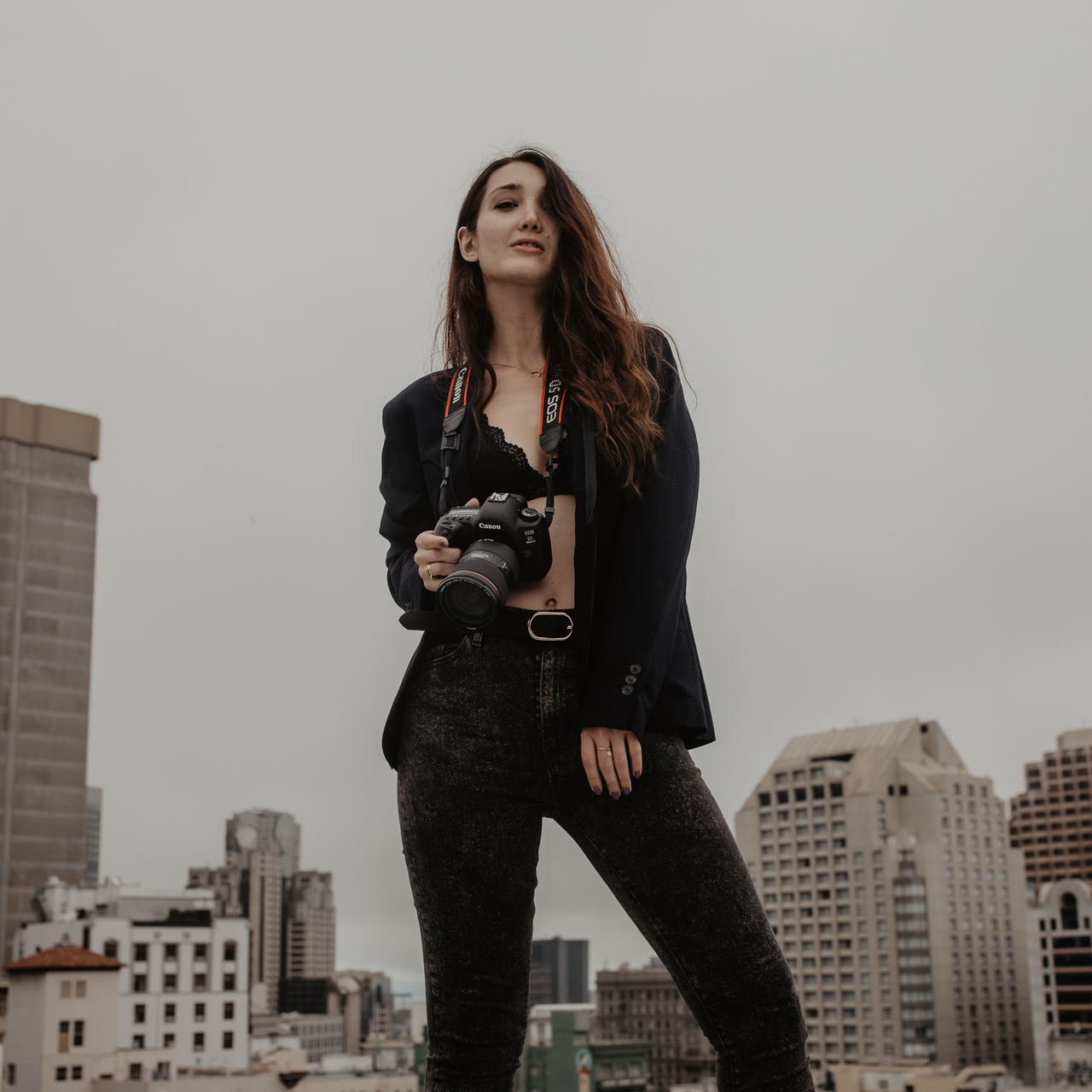 Mady holding her camera on a rooftop